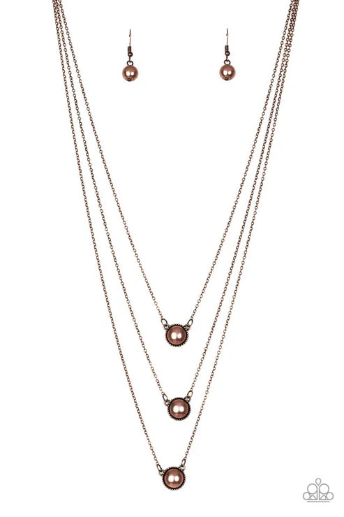 Necklace and earrings set with pink pearls on a white background