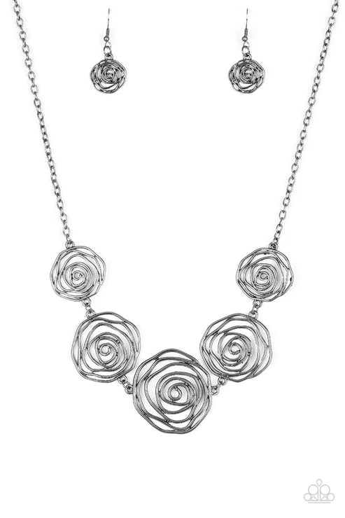 Silver rose-shaped necklace and earrings on a white background
