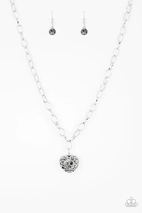 Silver necklace with heart pendant on a white background