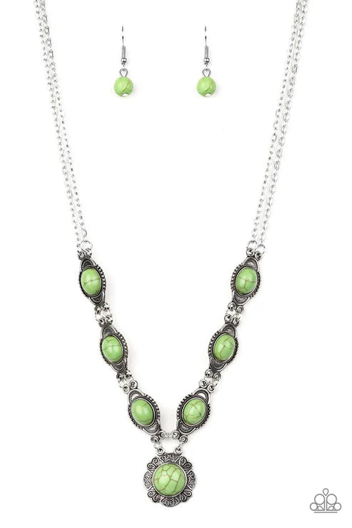 Necklace and earrings with green stones on a white background