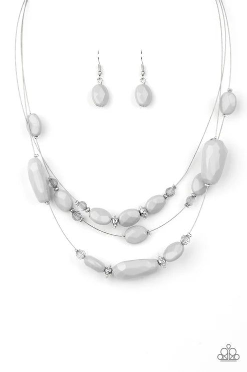 Necklace and earrings set with white beads on a white background