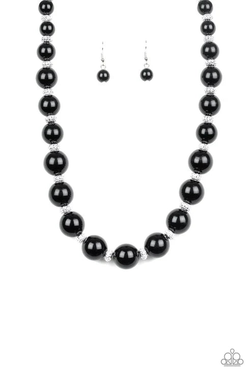Black beaded necklace and earrings on a white background
