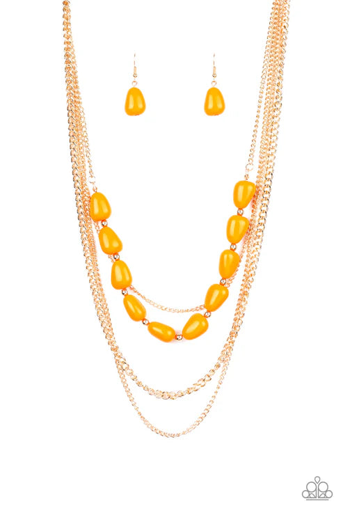 Necklace and earrings set with yellow beads and gold chains on a white background