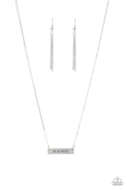 Silver necklace and earrings on a white background