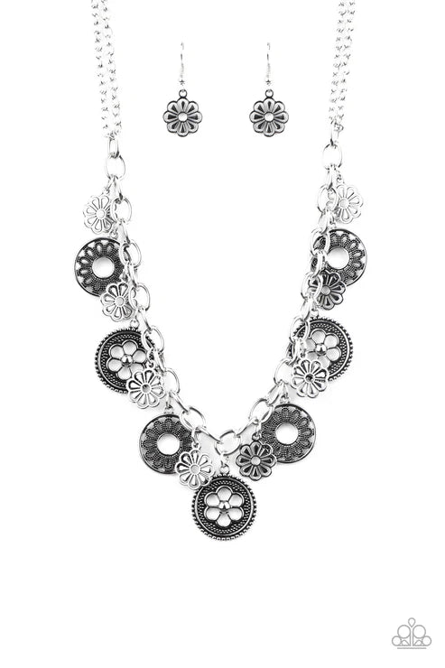 Silver floral necklace and earrings on a white background