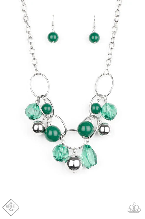 Jewelry set with green beads and silver accents on a white background