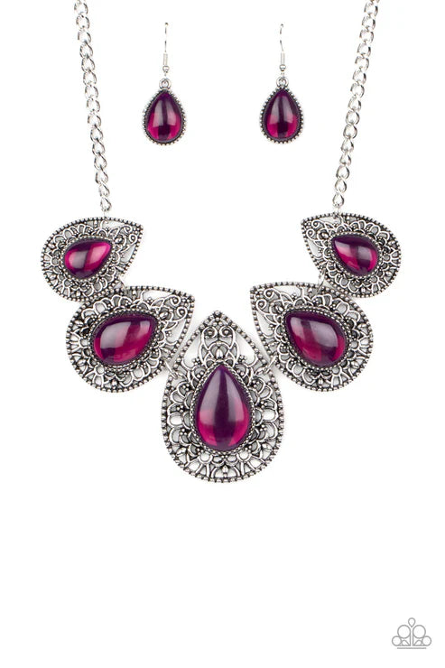 Jewelry set with teardrop-shaped red gemstones and silver accents on a white background