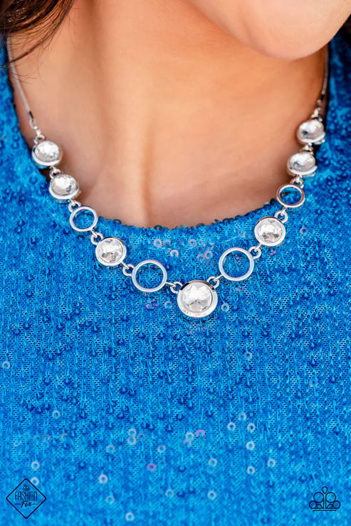 Silver necklace on a person wearing a blue sequin top