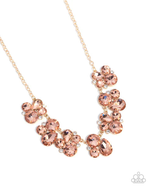 Rose gold necklace with pink gemstones on a white background