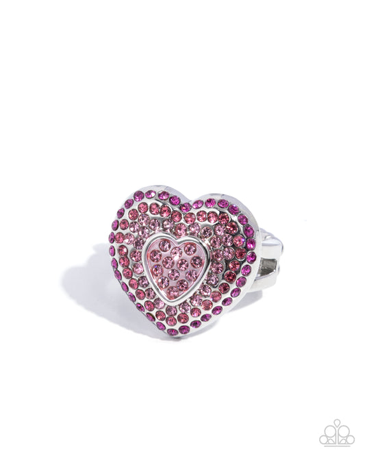Heart-shaped ring with pink and silver design on a white background
