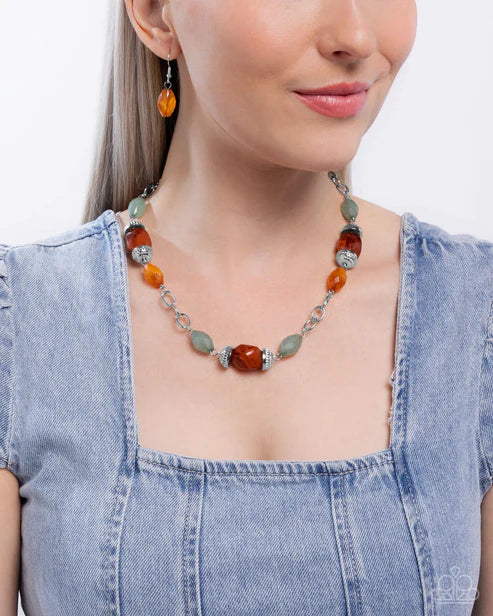 Woman wearing a colorful beaded necklace and earrings on a plain background