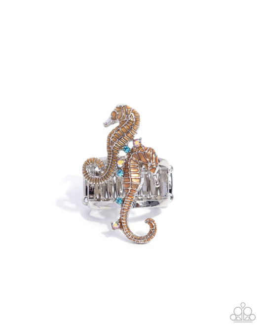 Silver ring with a seahorse design on a white background