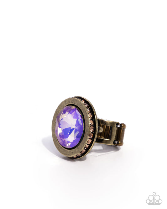 Purple gemstone ring with gold band on a white background