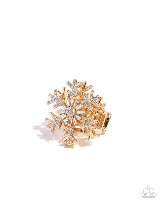 Gold and silver snowflake-shaped brooch on a white background