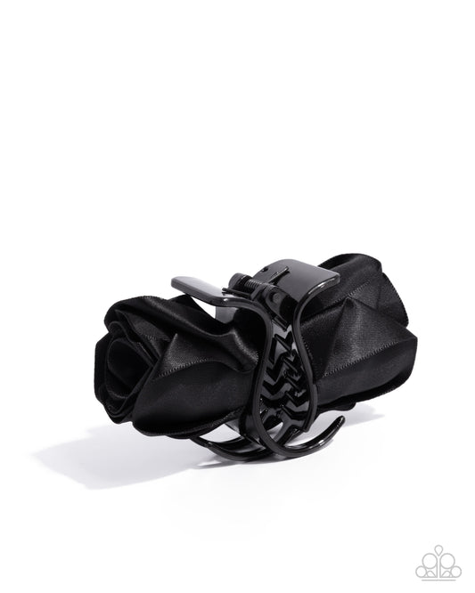 Black hair clip with floral design on a white background