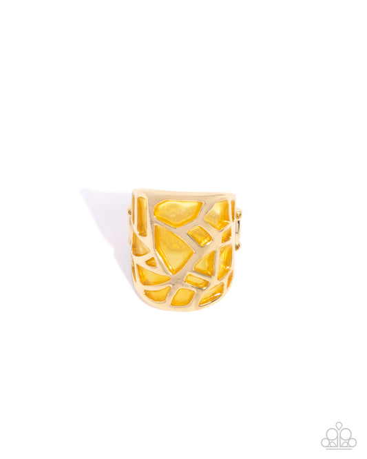 Gold ring with geometric design on a white background