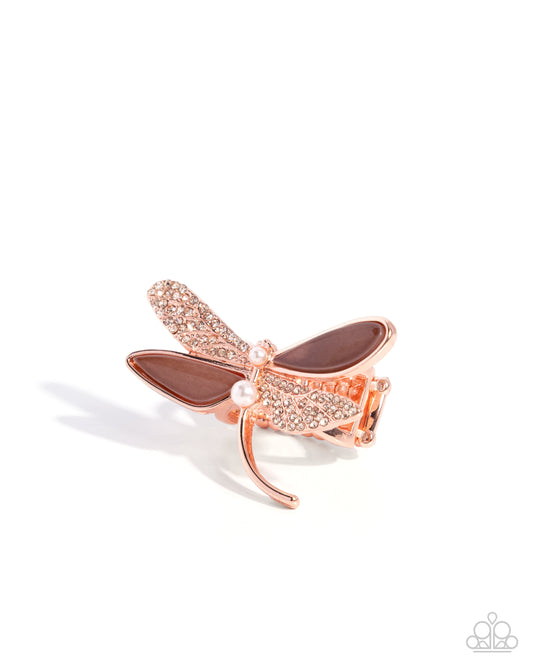 Rose gold dragonfly brooch with brown accents on a white background