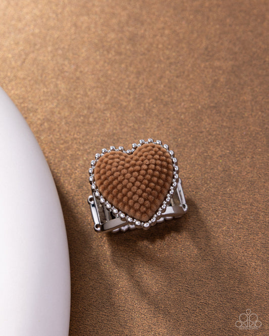 Heart-shaped brown clip with silver border on a brown background