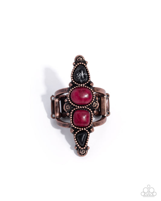 Decorative ring with pink and black stones on a white background