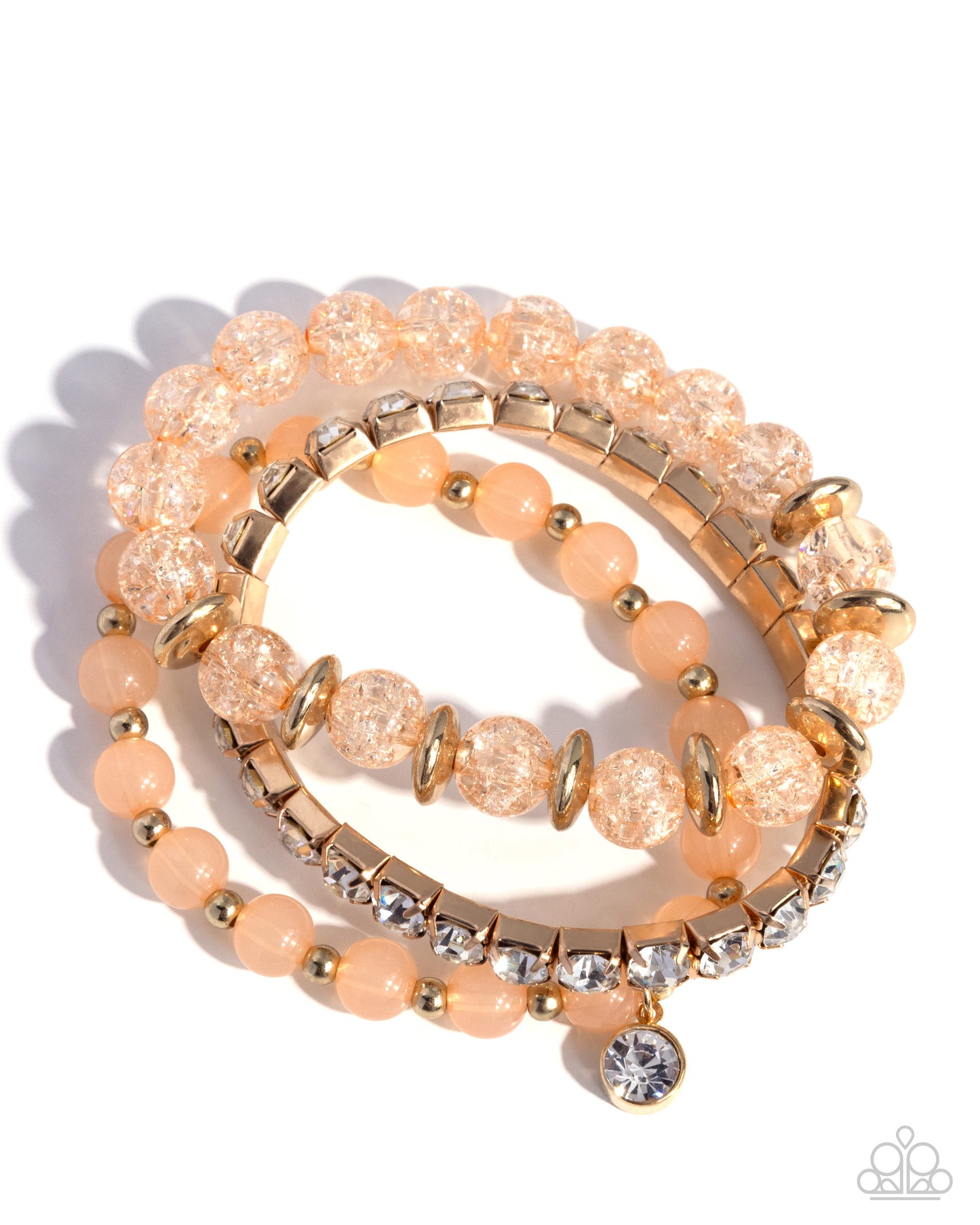 Set of peach and gold beaded bracelets on a white background
