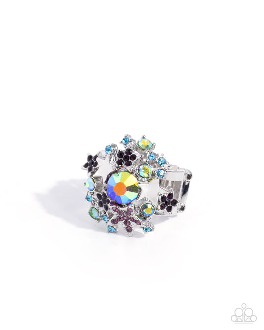 Multicolored gemstone ring with a central rainbow-colored gem on a white background