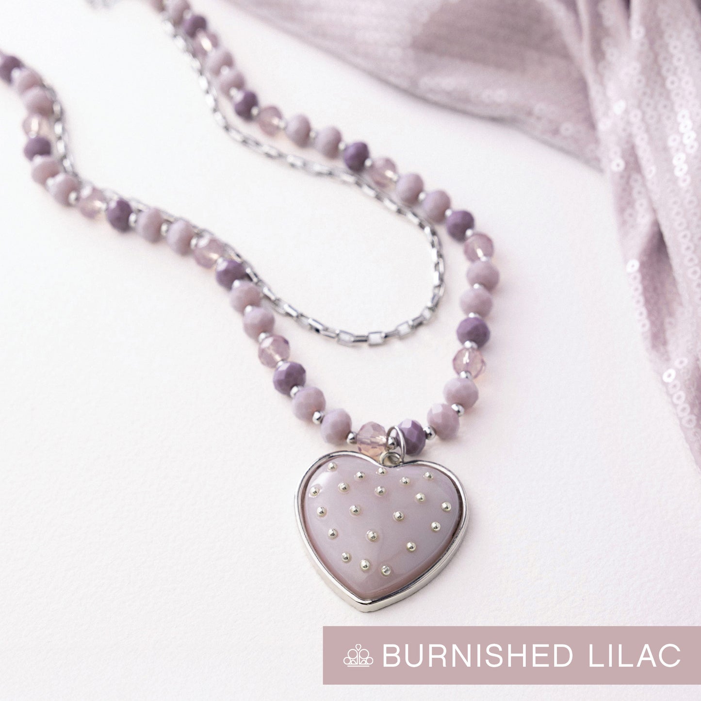 Necklace with a heart-shaped pendant on a white background, labeled 'Burnished Lilac'.