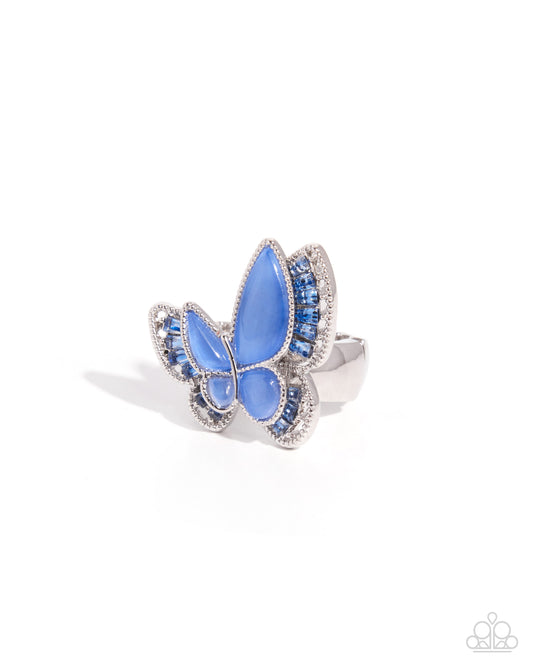 A butterfly-shaped ring featuring light blue cabochon stones set in a silver-toned metal with small clear stones, photographed on a clean white background.