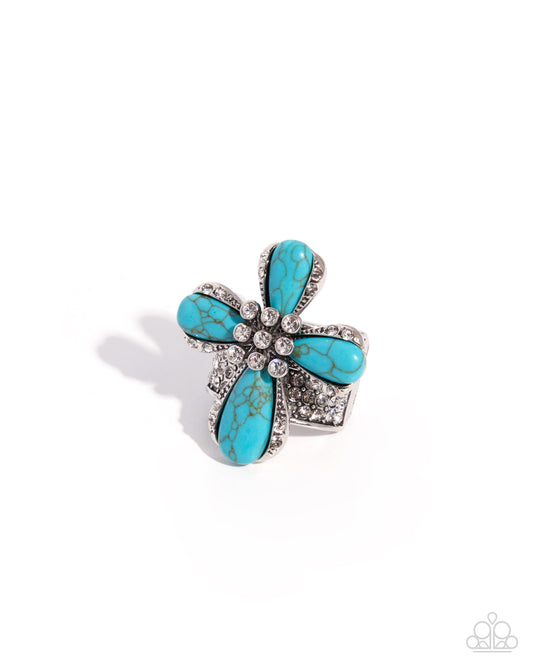 Turquoise flower-shaped brooch with silver accents on a white background