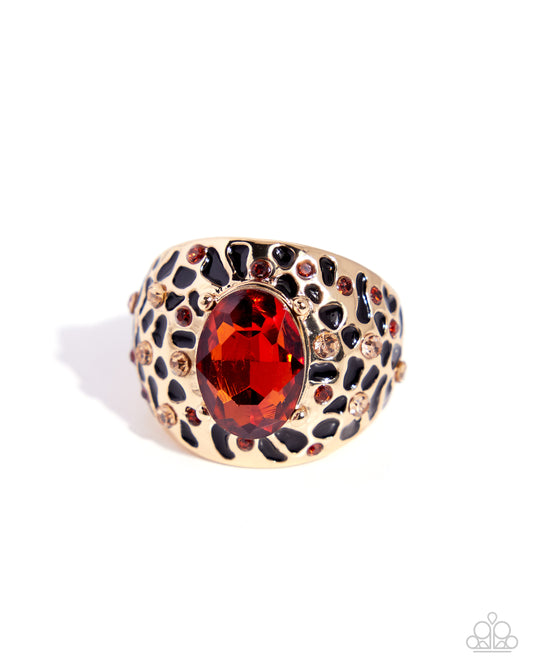 Gold ring with a red gemstone on a white background