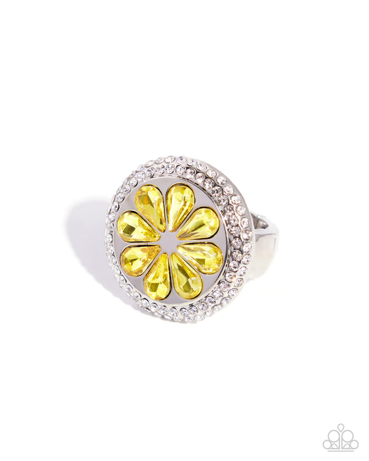 Silver ring with a yellow gemstone on a white background