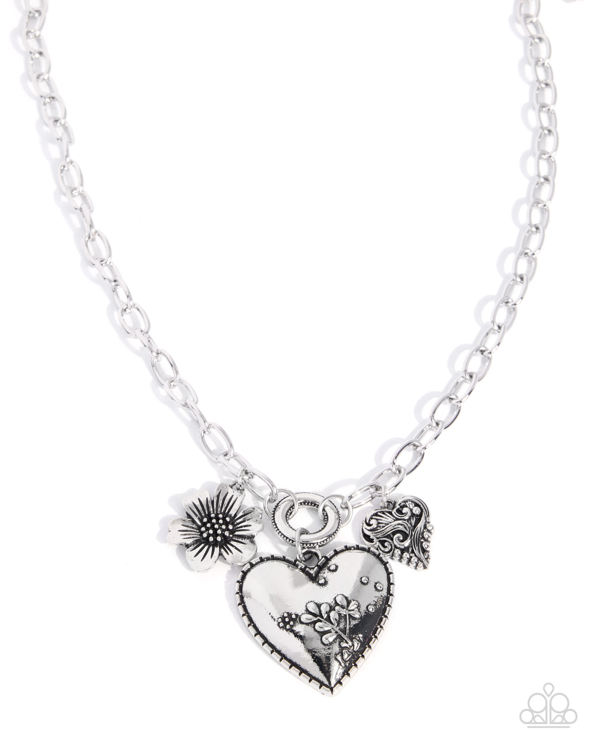 A silver-tone chain necklace featuring three charms: a central heart pendant with floral engraving, a dandelion, and a small angel wing charm, shown on a plain white background.