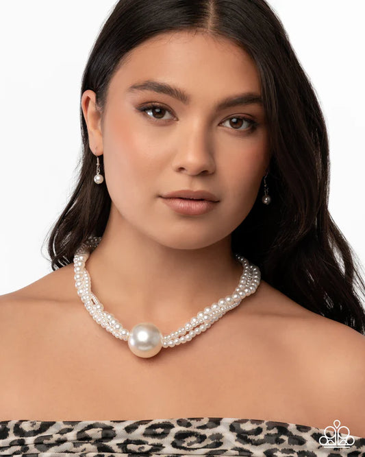 Woman wearing a pearl necklace with a neutral background