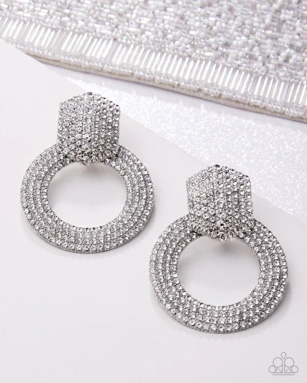 Silver hoop earrings with a textured design on a white background