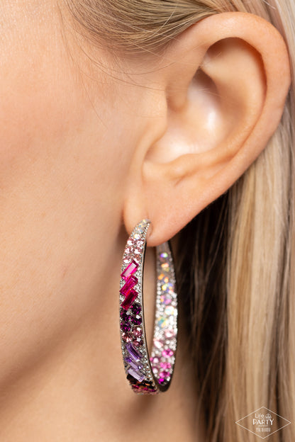 Close-up of an ear wearing a colorful hoop earring with a blurred background