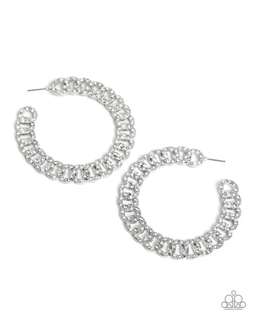 Silver hoop earrings with clear gemstones on a white background