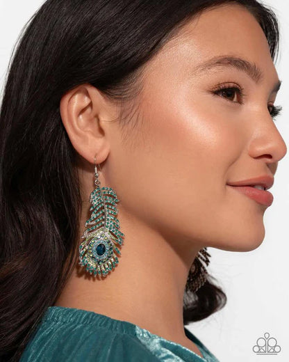 Close-up of a woman wearing a teal earring with a white background