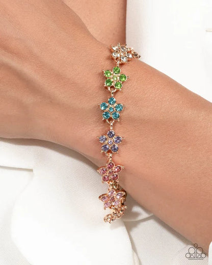Multicolored floral bracelet on a wrist with a white background