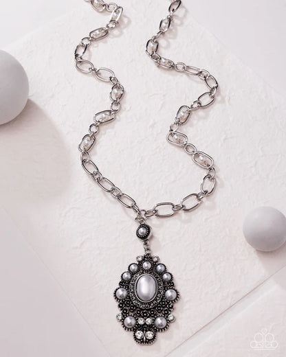 Silver chain necklace with a decorative pendant on a light background