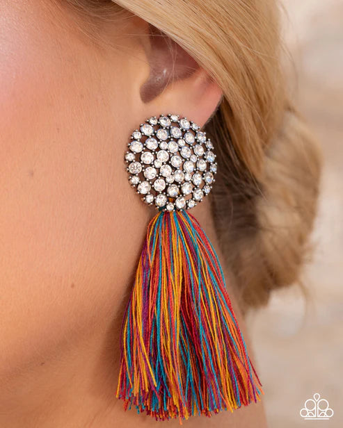 Earring with colorful tassel and rhinestone detail worn by a person.