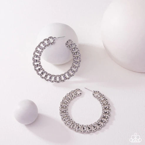 Silver hoop earrings with gemstones on a white background