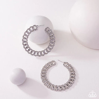 Silver hoop earrings with gemstones on a white background