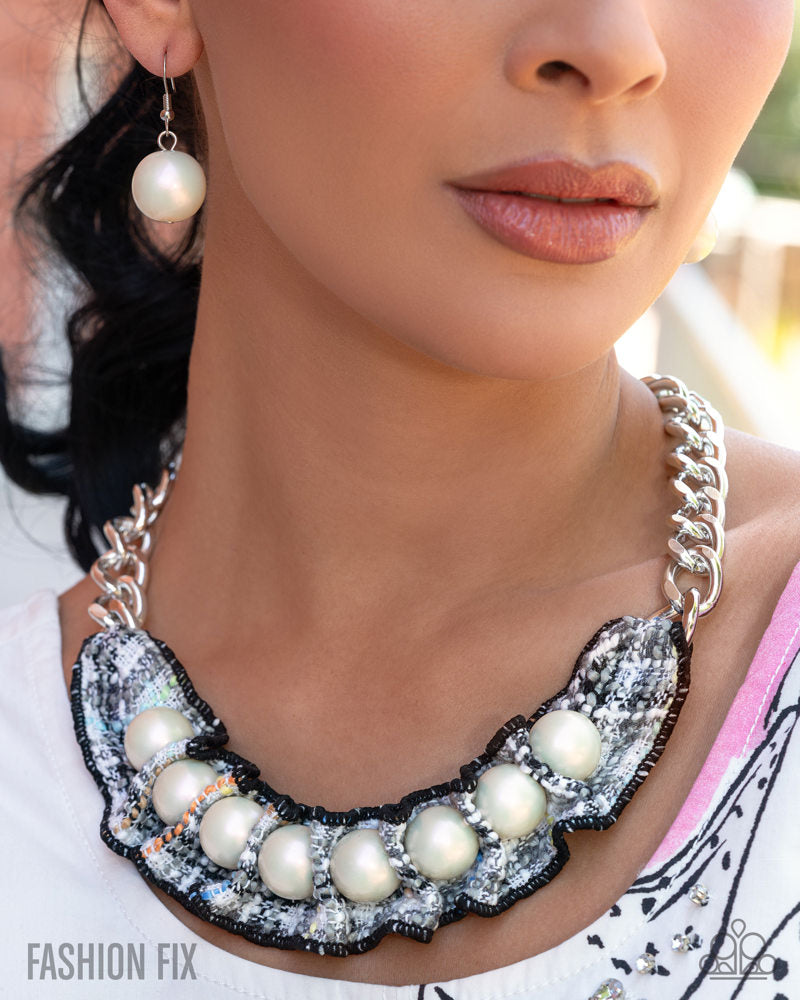Close-up of a person wearing a pearl necklace and earrings with blurred background
