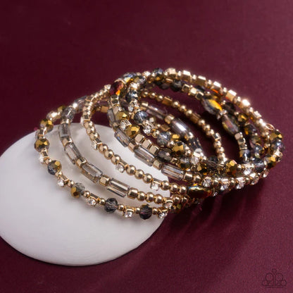 Set of beaded bracelets on a white dish with a maroon background