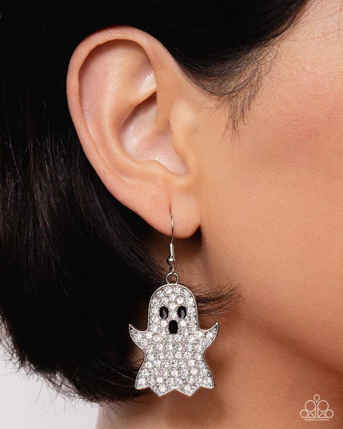 Ghost-shaped earring worn on an ear with a plain background