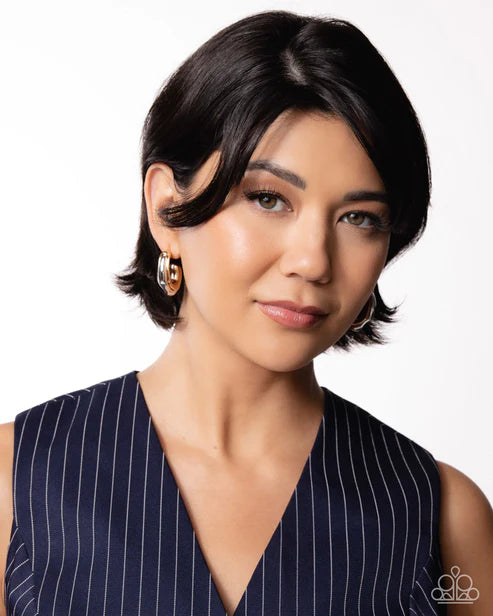Woman wearing a navy pinstripe dress with a plain background