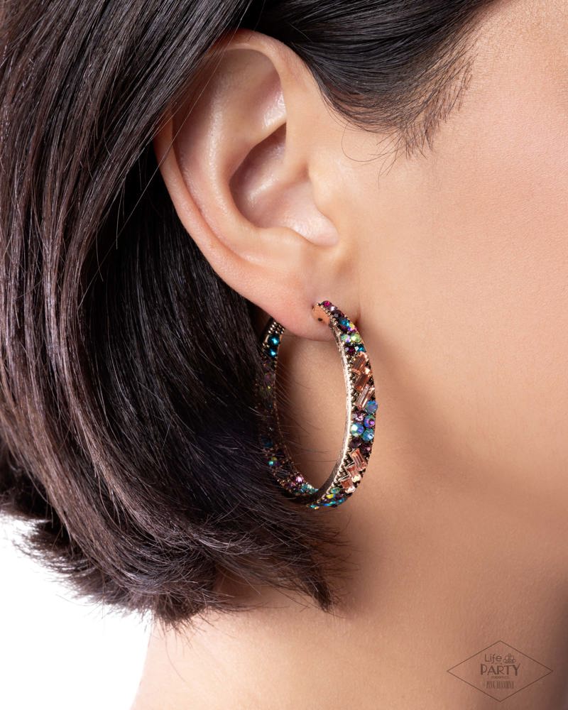 Close-up of an ear wearing a colorful hoop earring with a blurred background