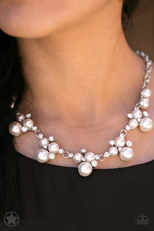 Pearl necklace being worn on a person with a blurred background