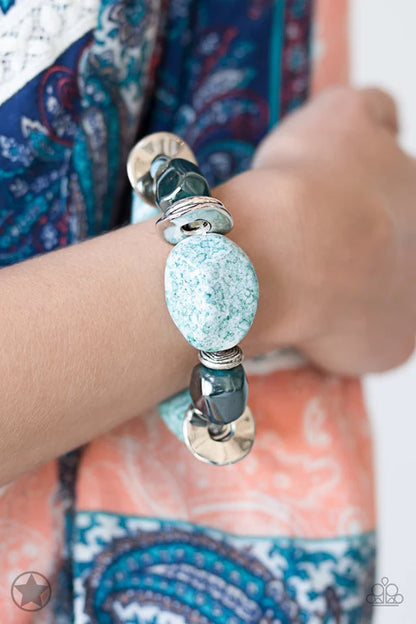 Close-up of a hand wearing a bracelet with turquoise bead and silver accents.