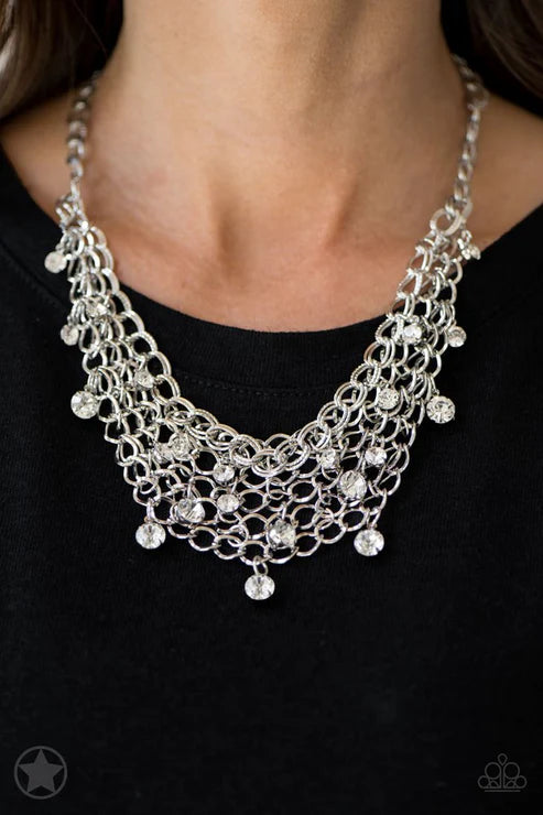 Silver necklace with dangling beads on a black background
