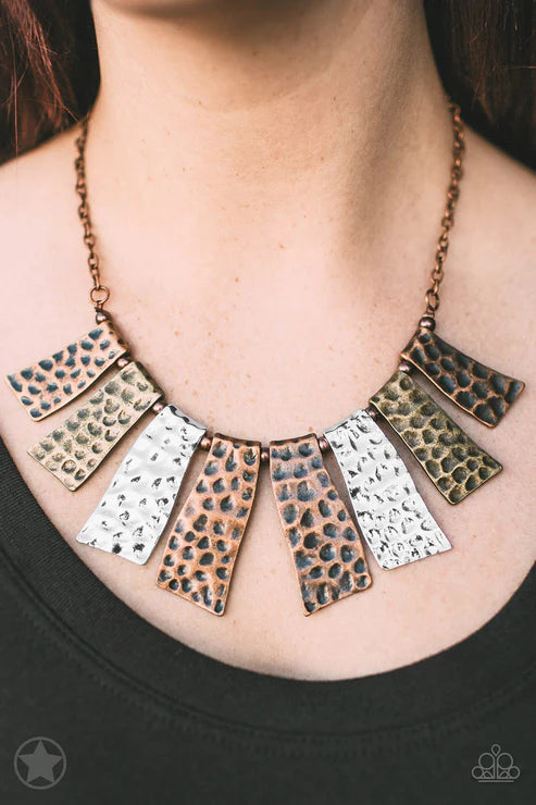 Necklace with patterned pendants worn by a person on a black background